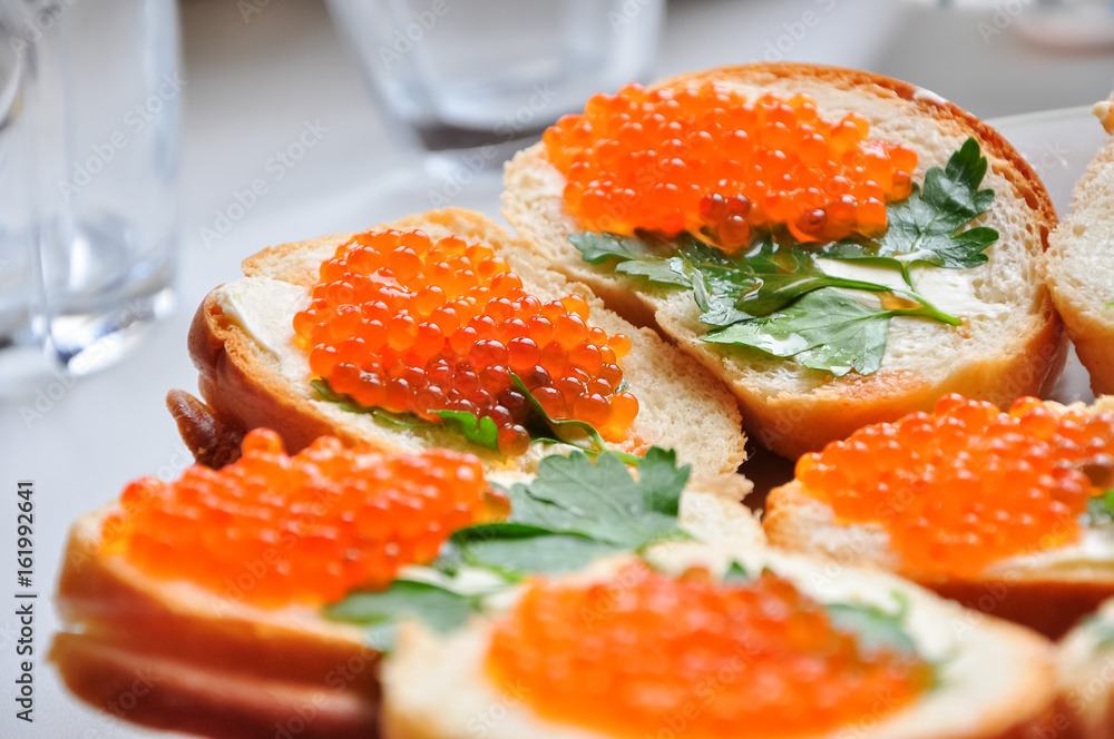 Photo of baguette with red caviar on white table Photo of baguette with red caviar on white table