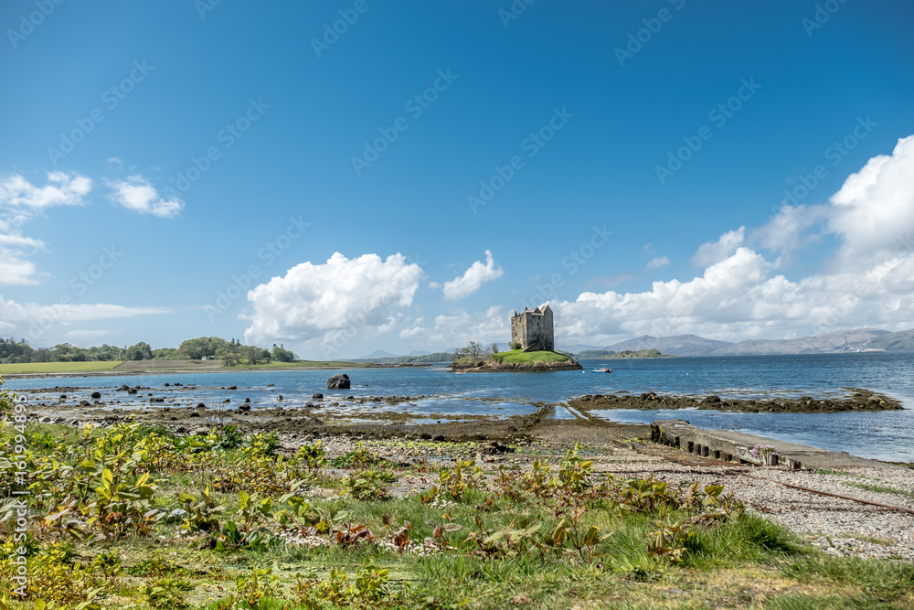 Canoes gathering at the historic castle Stalker in Argyll