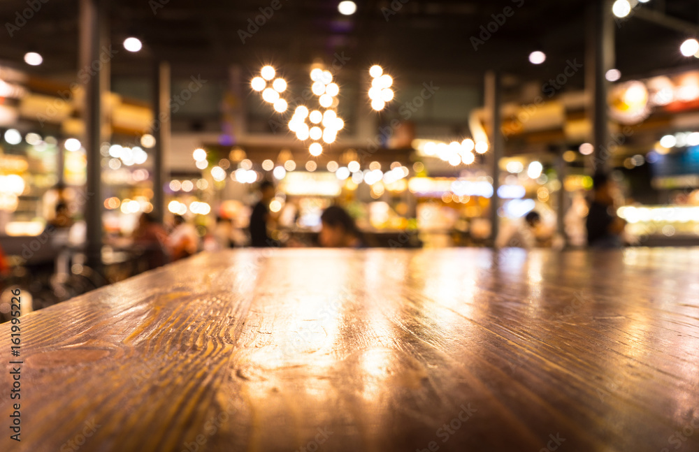 Empty wood table top on blur light gold bokeh of cafe restaurant in dark background/selective focus.