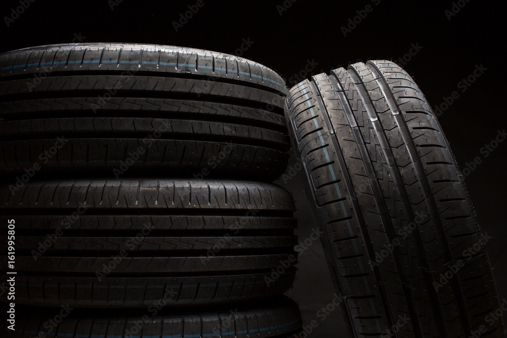 Stack of brand new high performance car tires on clean high-key white studio background Stack of brand new high performance car tires on clean high-key white studio background