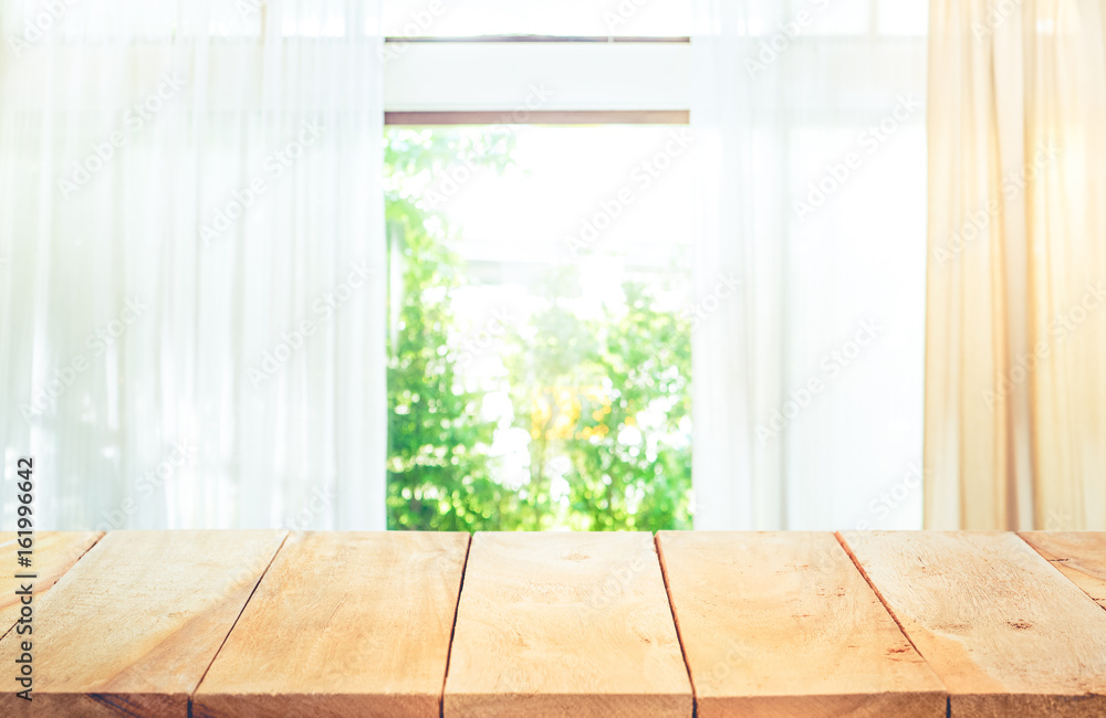 Empty of wood table top on blur of curtain window and abstract green from garden with sunlight .For montage product display or key visual layout Empty of wood table top on blur of curtain window and abstract green from garden with sunlight .For montage product display or key visual layout