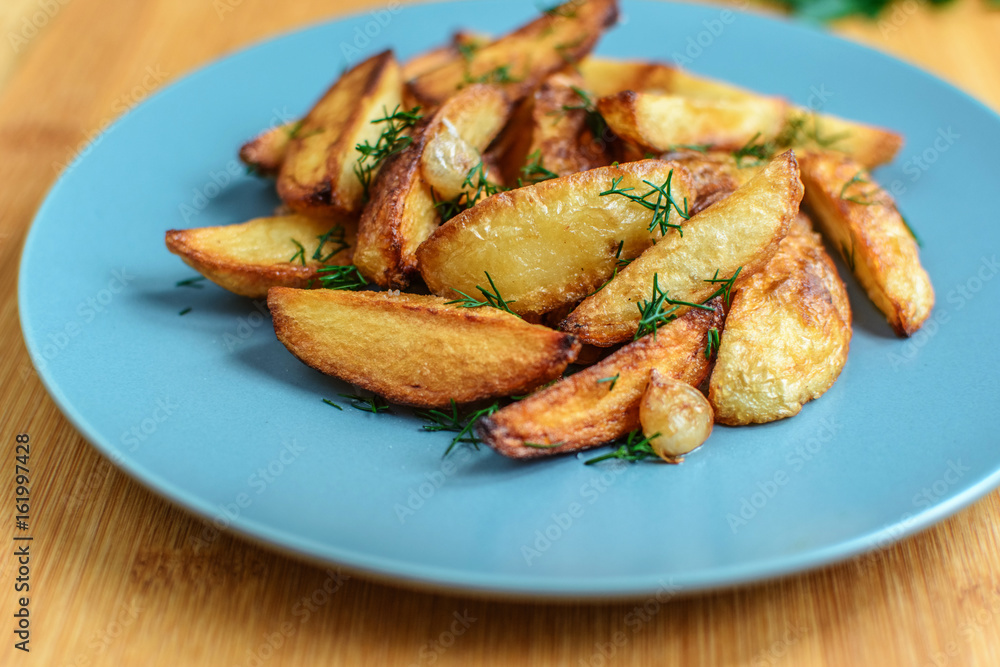 Roasted potatoes with salt pepper and cumin on wooden background Roasted potatoes with salt pepper and cumin on wooden background