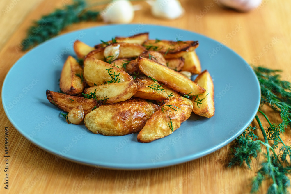 Roasted potatoes with salt pepper and cumin on wooden background Roasted potatoes with salt pepper and cumin on wooden background