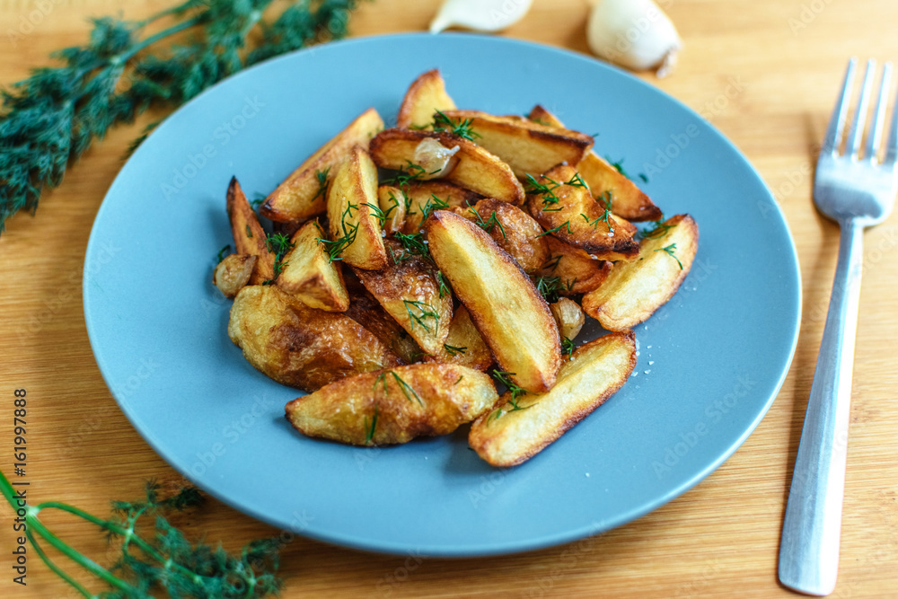 Roasted potatoes with salt pepper and cumin on wooden background Roasted potatoes with salt pepper and cumin on wooden background