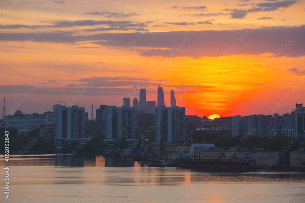 Fototapeta premium Sunrise at the city. Silhouette of buildings.