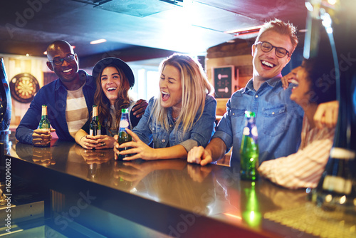 Фотография Laughing group of people drinking in tavern