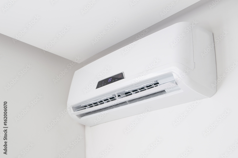 White split air conditioner closeup on a white wall. Home interior in a small apartment White split air conditioner closeup on a white wall. Home interior in a small apartment