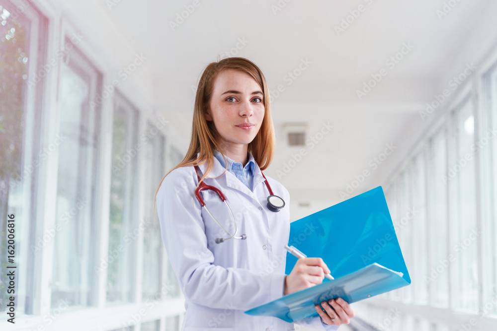 Beautiful young smiling female doctor portrait with folder Beautiful young smiling female doctor portrait with folder