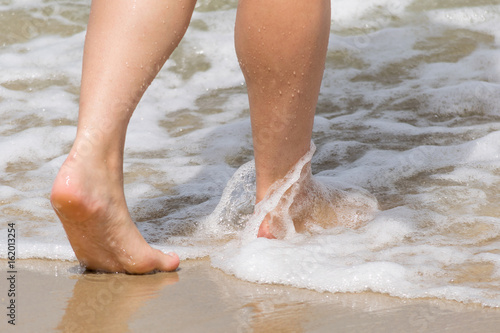 Two feet walking through the waves