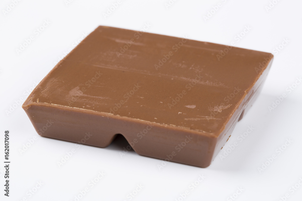 One square piece of chocolate, isolated on white. One square piece of chocolate, isolated on white.