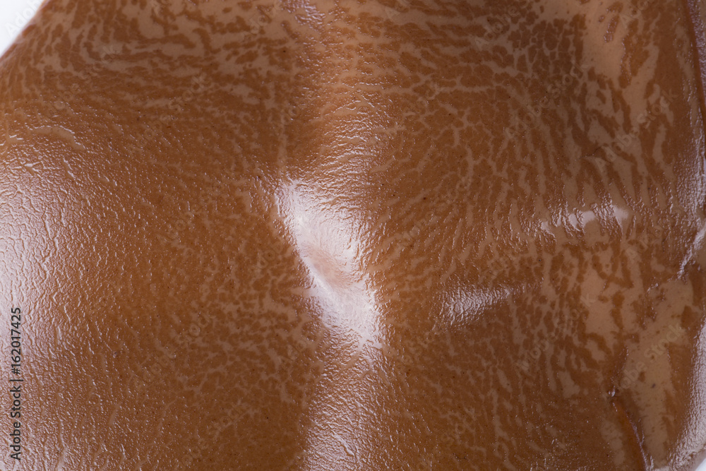 Melting piece of dark chocolate on white background.