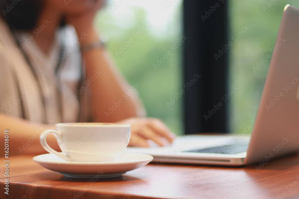 Get some rest. Cheerful delighted beautiful woman drinking coffee and working on the laptop while resting in the cafe Get some rest. Cheerful delighted beautiful woman drinking coffee and working on the laptop while resting in the cafe