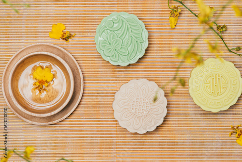Sweet color of snow skin mooncake. Traditional mid autumn festival foods with tea on table setting.