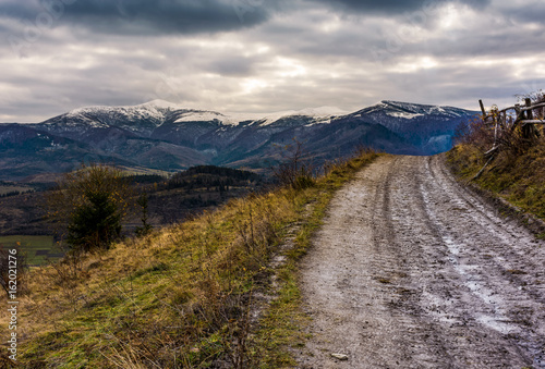 countryside road to snowy mountain ridge