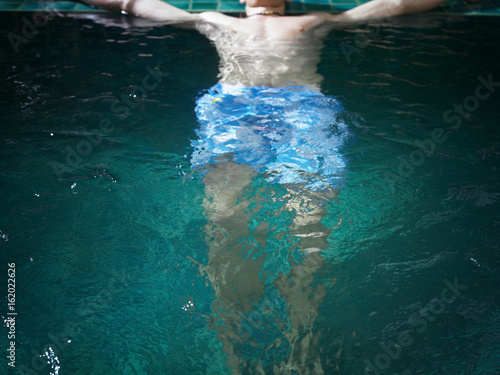 crop off shot of man floating in the spa pool