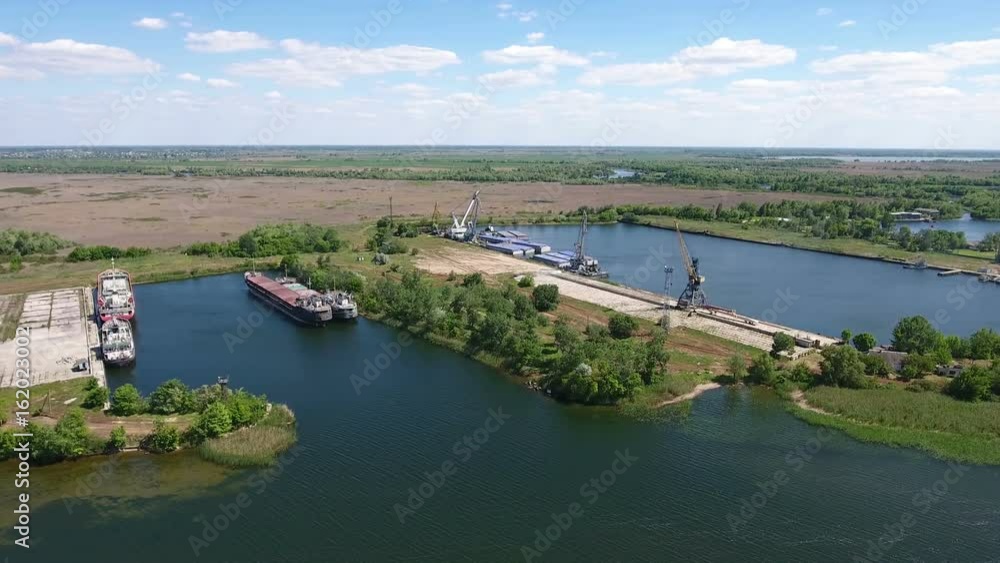 Unusual aerial shot of the Dnipro and its picturesque riverbanks in Kherson region in Ukraine in a sunny day in summer. The quay with modern docks and ships looks fine and gorgeous. Unusual aerial shot of the Dnipro and its picturesque riverbanks in Kherson region in Ukraine in a sunny day in summer. The quay with modern docks and ships looks fine and gorgeous.