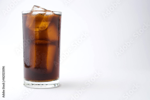 cola with ice in glass on white background with copy space