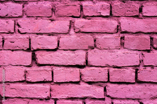 Pink paint on a brick wall