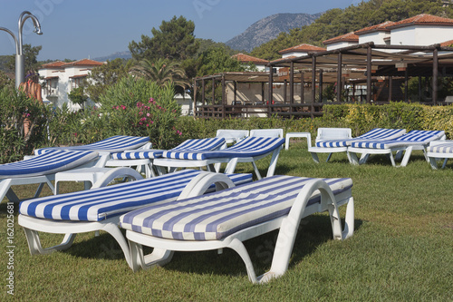 Empty chaise lounges with mattresses on the lawn at the hotel in Turkey. Camyuva, Kemer photo