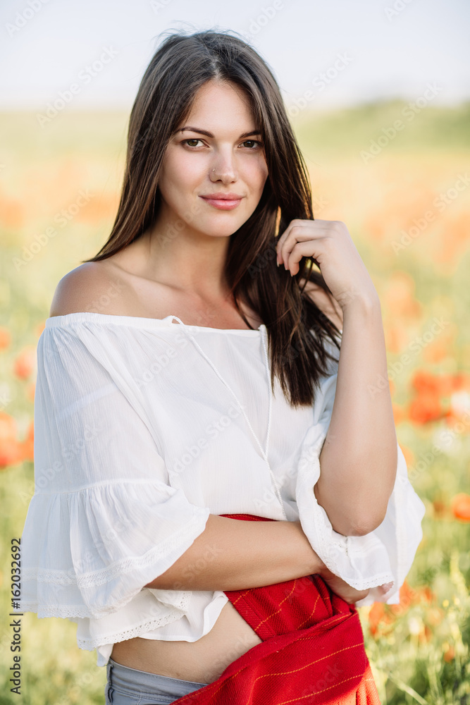 beautiful girl in a poppy field at sunset beautiful girl in a poppy field at sunset