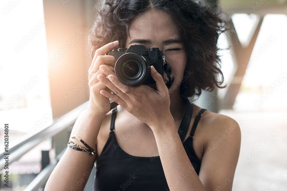 young woman using a camera to take photo outdoors at balcony building young woman using a camera to take photo outdoors at balcony building