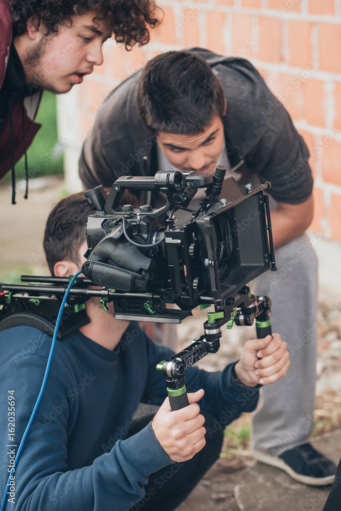 Behind the scene. Cameraman and assistant shooting film with camera Behind the scene. Cameraman and assistant shooting film with camera