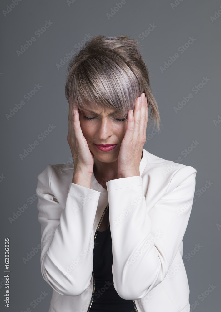 Young woman has headache, isolated on gray background Young woman has headache, isolated on gray background