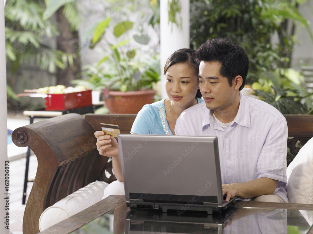 man teaching woman to use laptop to make payment man teaching woman to use laptop to make payment