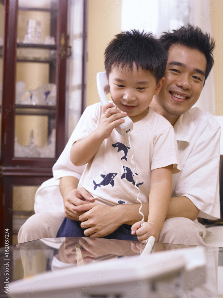 father and son enjoy making phone call father and son enjoy making phone call
