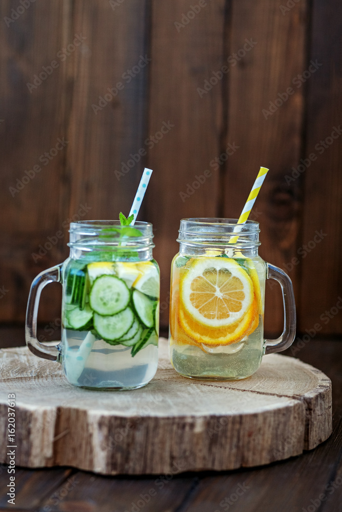 Fototapeta premium Lemonade of lemon, cucumber, orange and mint. Detox water. Top view. The concept of a diet, a vegetarian, healthy food and a lifestyle.