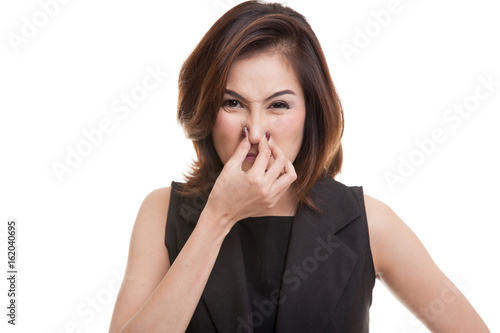 Young Asian woman holding her nose because of a bad smell.