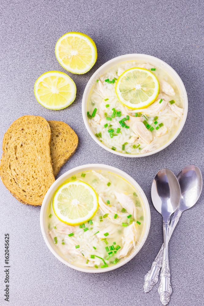 Traditional Greek lemon orzo chicken soup on stone background. Traditional Greek lemon orzo chicken soup on stone background.