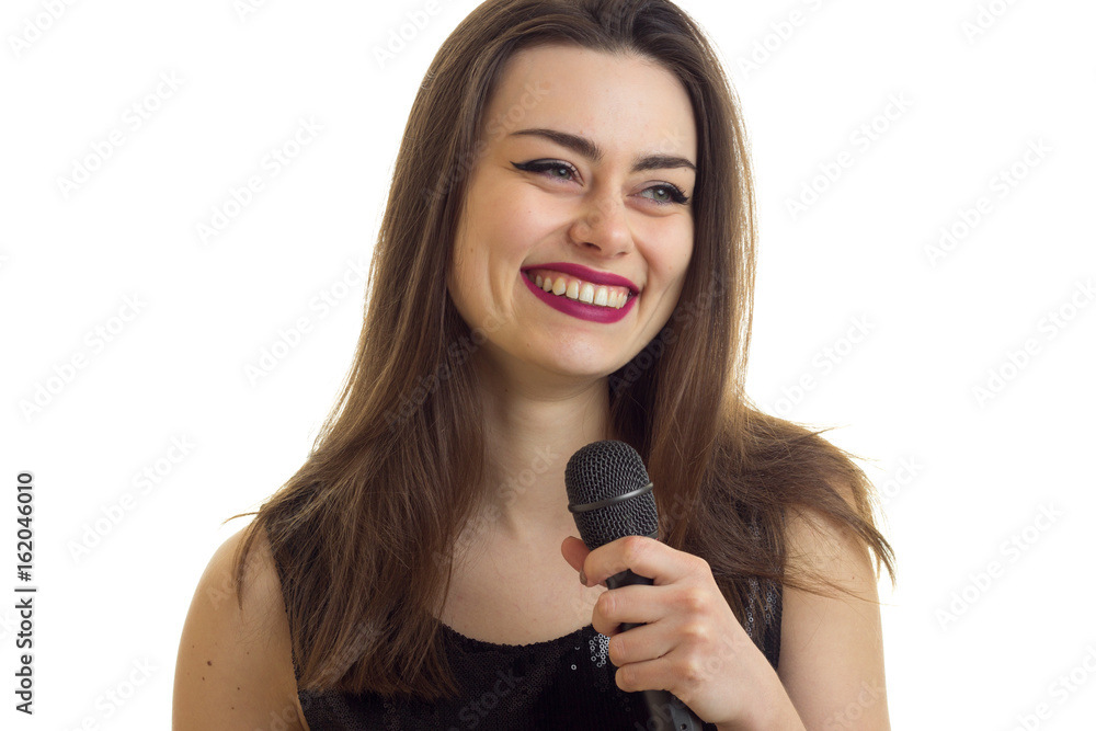 Cheerful woman with beautiful make up smiling with microphone in hands Cheerful woman with beautiful make up smiling with microphone in hands