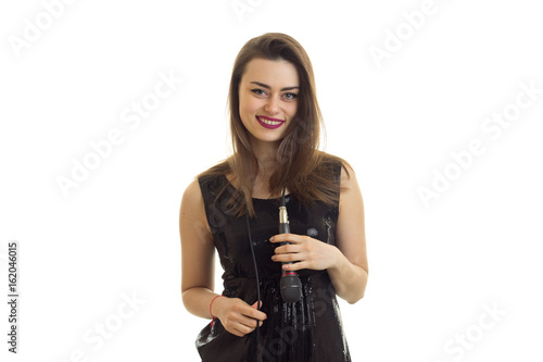 Beautiful woman in bright black dress smiling on camera with microphone on her neck