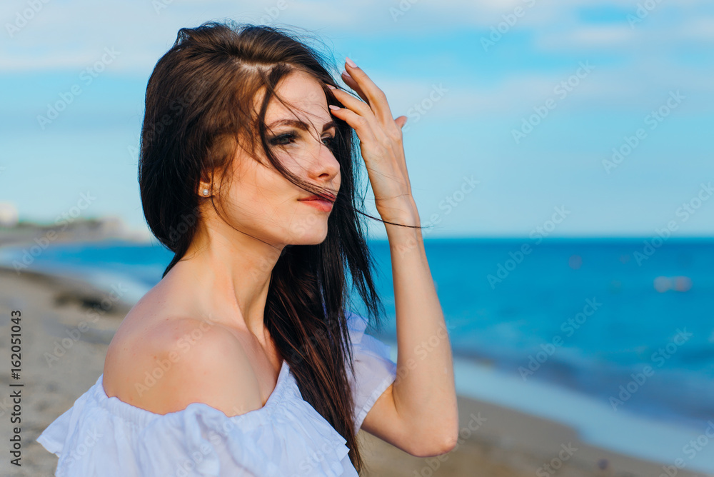 Woman in hat and white dress on the background of the sea Woman in hat and white dress on the background of the sea