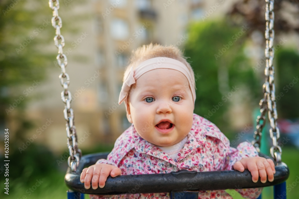 Baby fun riding on the swings at the Park.