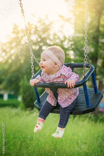 Baby fun riding on the swings at the Park.
