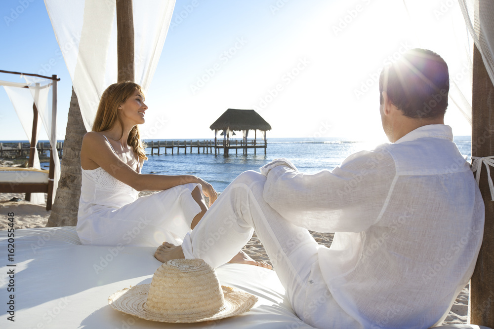couple au bord de la mer sur un lit blanc avec des voilages Stock Photo |  Adobe Stock