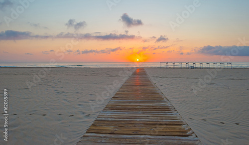Fototapeta Naklejka Na Ścianę i Meble -  Sunrise over sea and sandy beach in spring