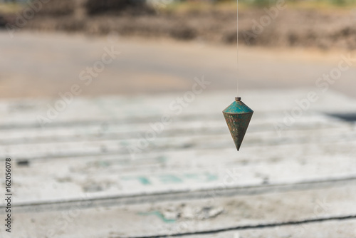 Schilderij op canvas metal plumb line used in construction site
