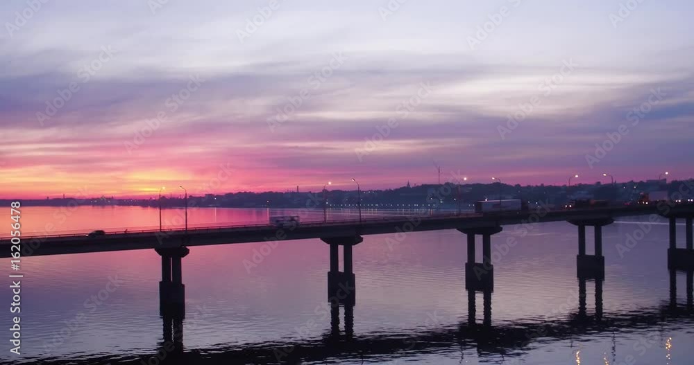 aerial view picturesque pink sunset over river and bridge with moving cars aerial view picturesque pink sunset over river and bridge with moving cars
