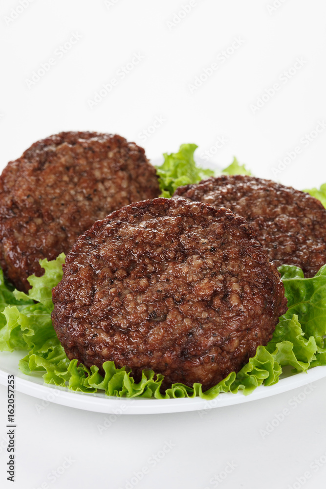 Roasted meatballs and lettuce leafs in white plate Roasted meatballs and lettuce leafs in white plate