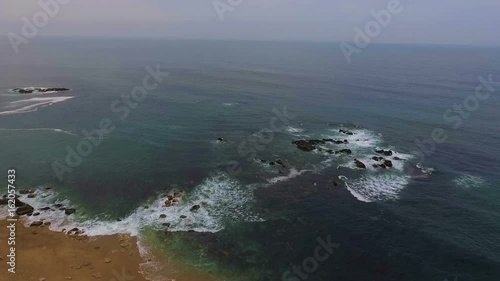 Aerial view of ocean Portugal waves crashing on beach, drone footage. photo