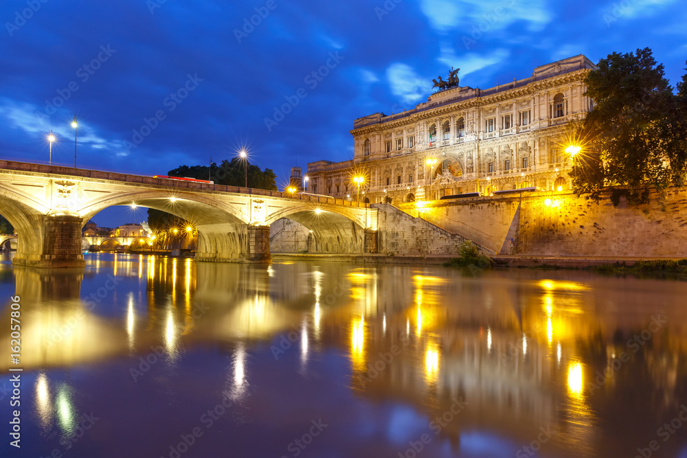 The Palace of Justice and bridge Ponte Umberto I with mirror reflection seen from the Tiber riverside during morning blue hour in Rome, Italy