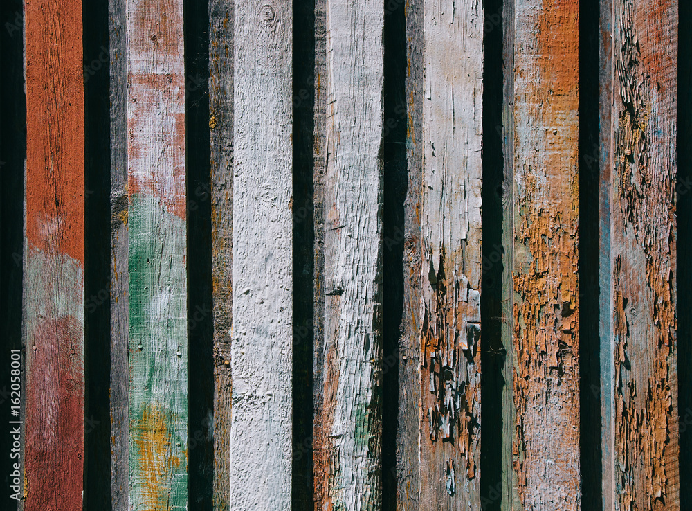 Bright wooden background from colored vertical boards with peeling paint
