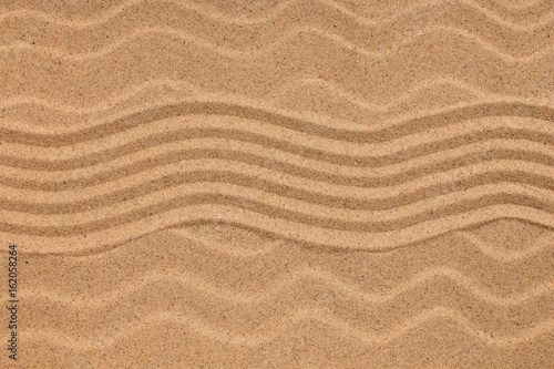 Zigzag on sand and seashells on wavy sand. Conceptual image.