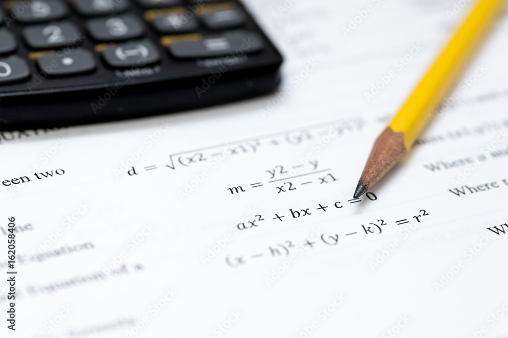 calculator and pencil isolated on a white background with mathematical formulas visible calculator and pencil isolated on a white background with mathematical formulas visible