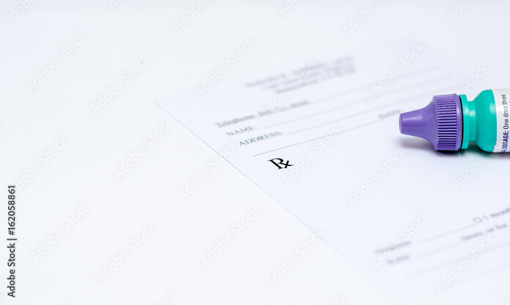 eye drop solution laying on prescription pad eye drop solution laying on prescription pad