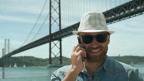 Man looks joyful while receiving good news on cellphone, steadycam shot
 photo