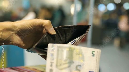 Woman taking cash from the wallet and holding euros, steadycam shot
